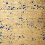 Detail of wallpaper in a paint splatter print in navy on a metallic gold field.