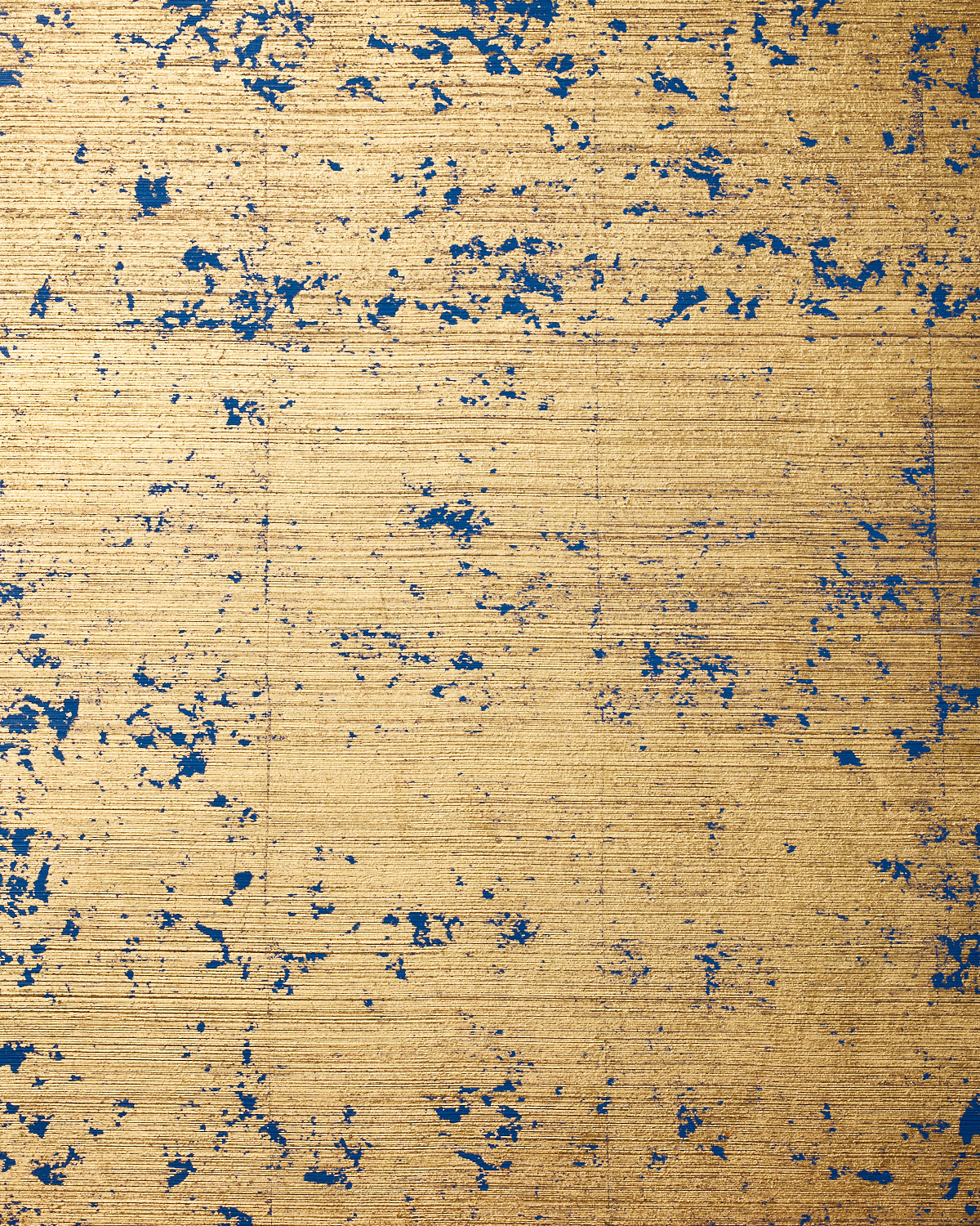 Detail of wallpaper in a paint splatter print in navy on a metallic gold field.