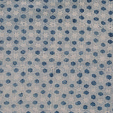 Detail of fabric in a star-shaped lattice print in navy on a cream field.