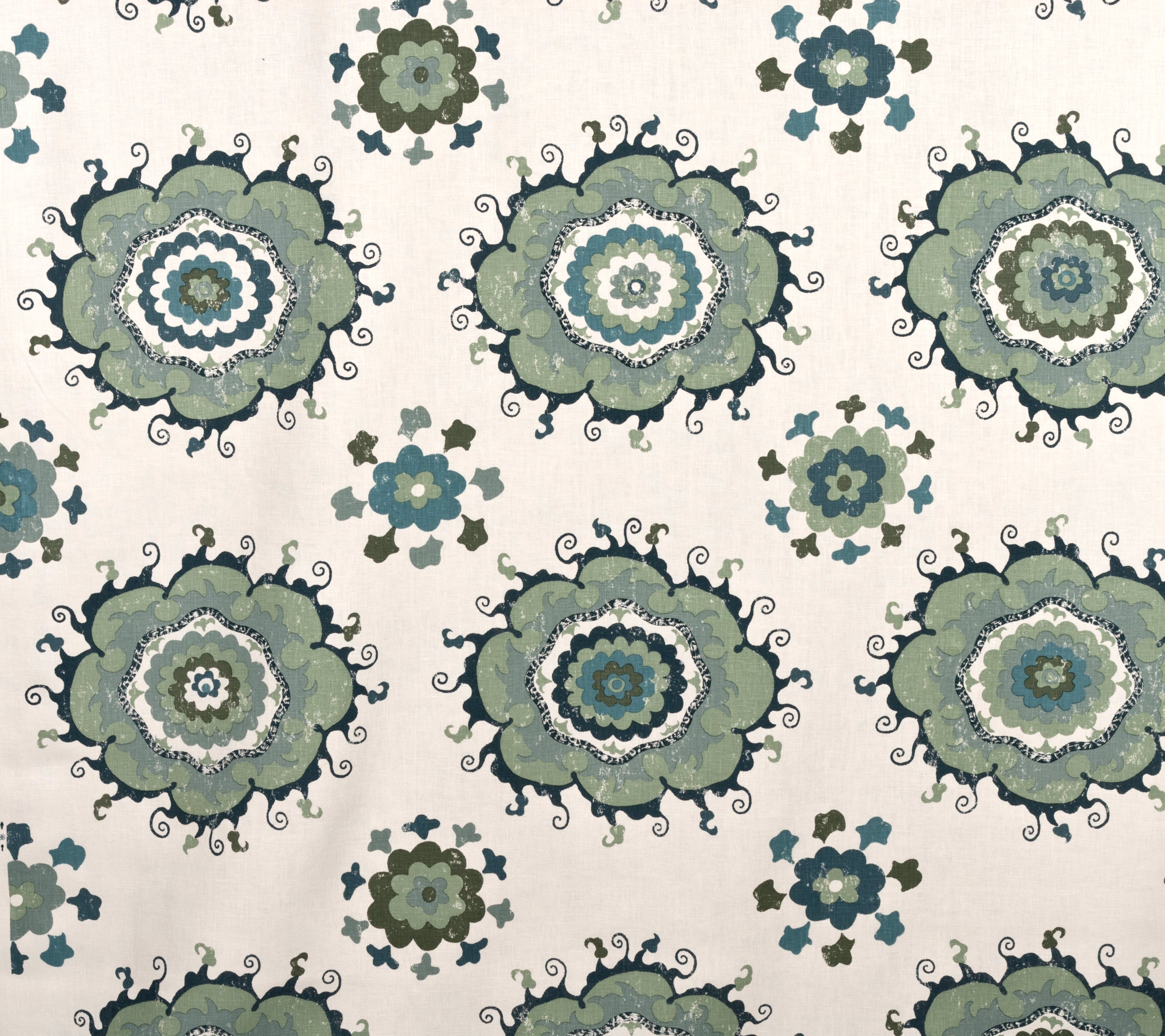 Detail of fabric in a floral paisley print in shades of blue, green and black on a cream field.