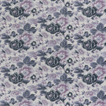 printed linen fabric in a detailed floral pattern in shades of purple and gray on a light gray field.