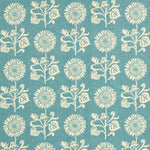 Detail of fabric in a repeating sunflower print in cream on a blue field.