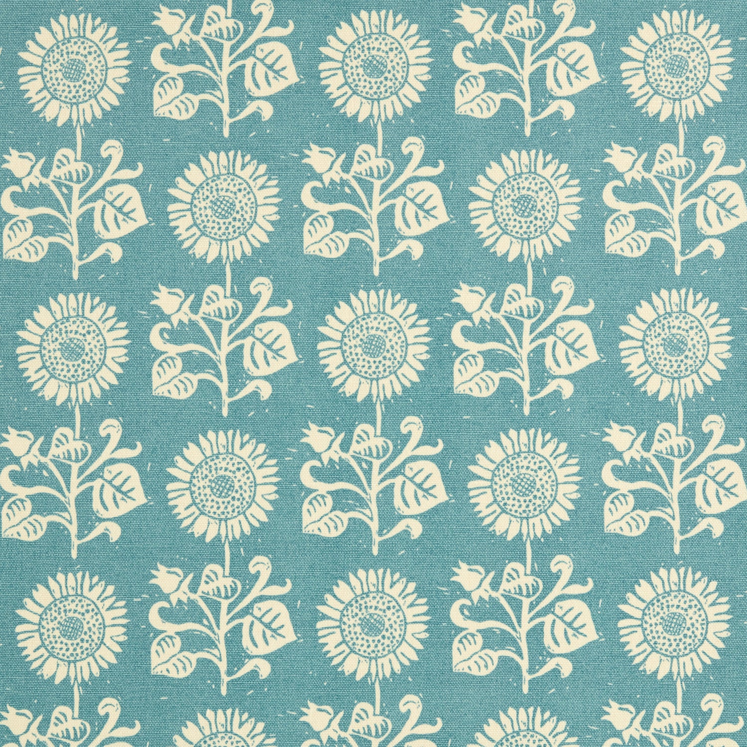 Detail of fabric in a repeating sunflower print in cream on a blue field.