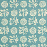 Detail of fabric in a repeating sunflower print in cream on a blue field.