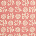 Detail of fabric in a repeating sunflower print in cream on a pink field.