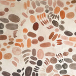 Detail of wallpaper in a playful paint blotch print in shades of brown and orange on a cream field.