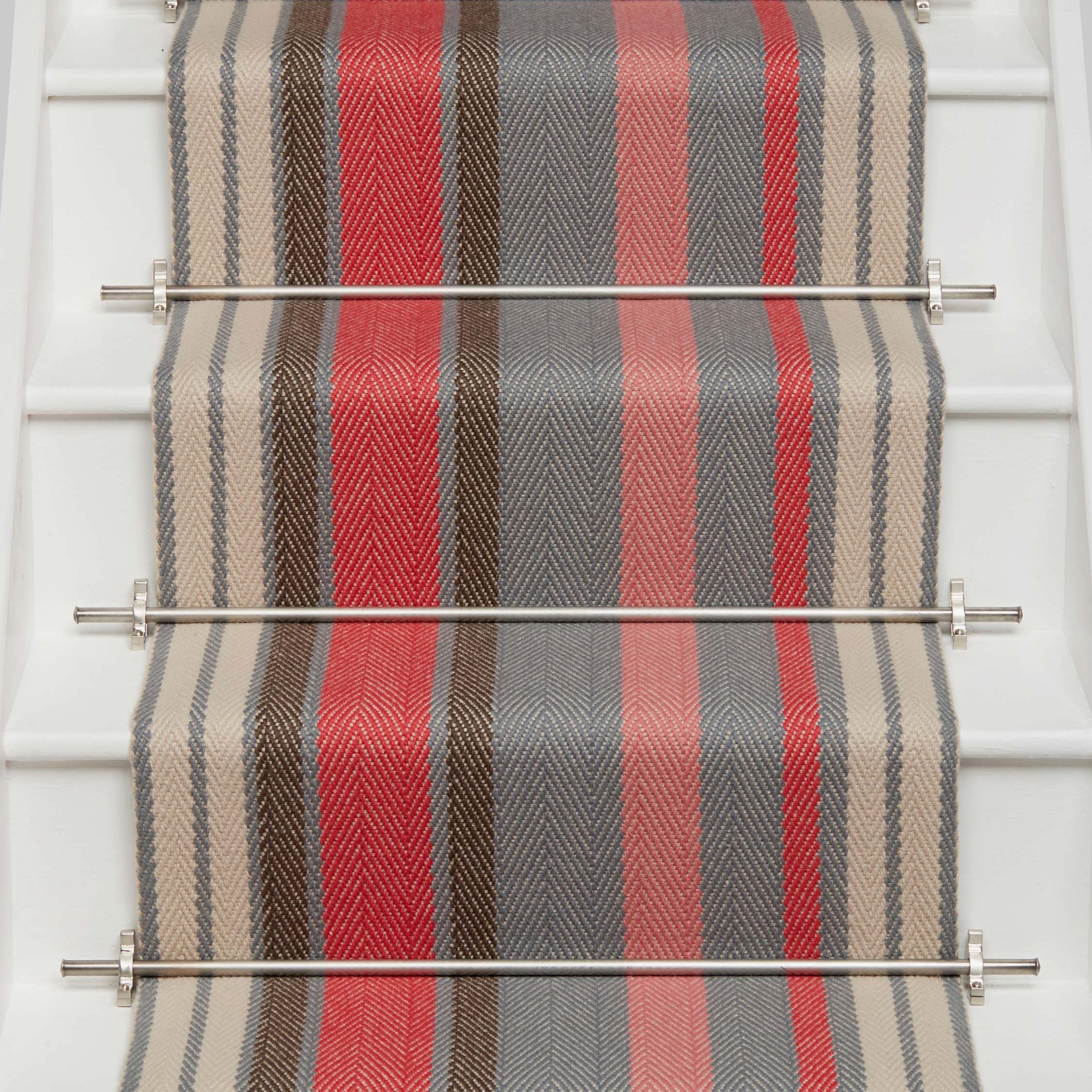 Striped flatweave runner in pink red grey and cream on white staircase