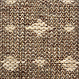 Close-up of a woven rug  with a diamond pattern in shades of cream on a brown field.