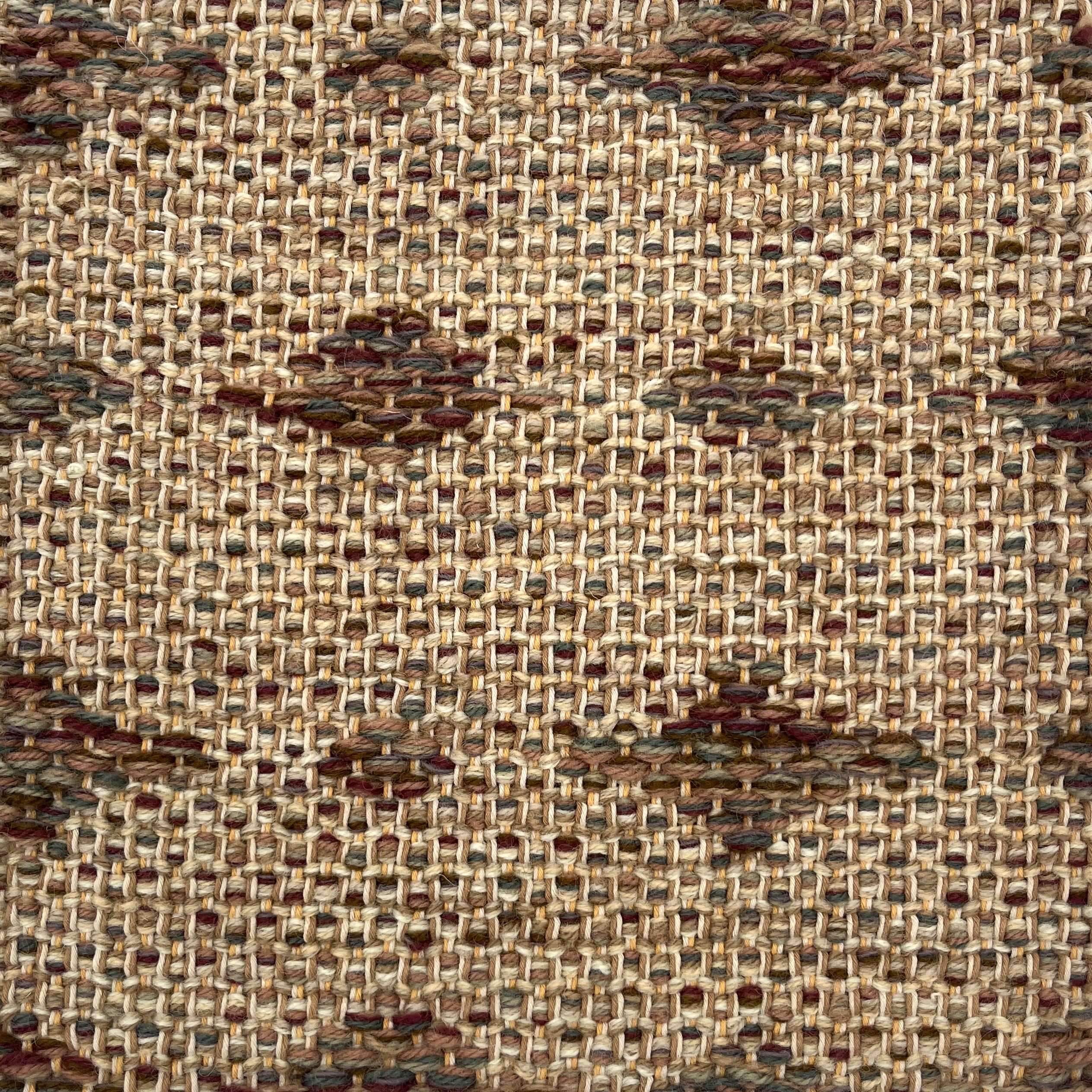 Close-up of a woven rug  with a diamond pattern in shades of brown.