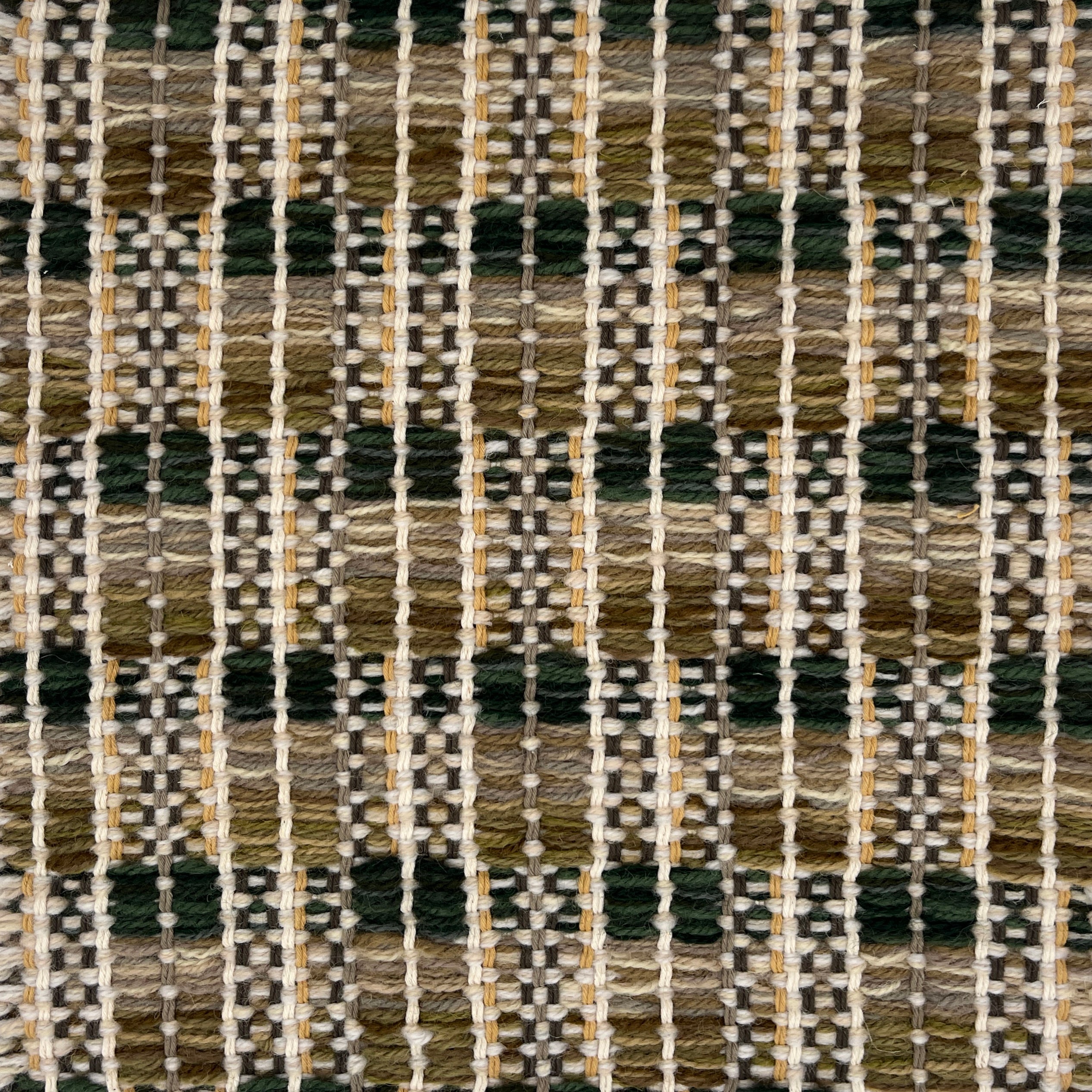 Close-up of a woven rug  with a geometric checker pattern in earthy tones.