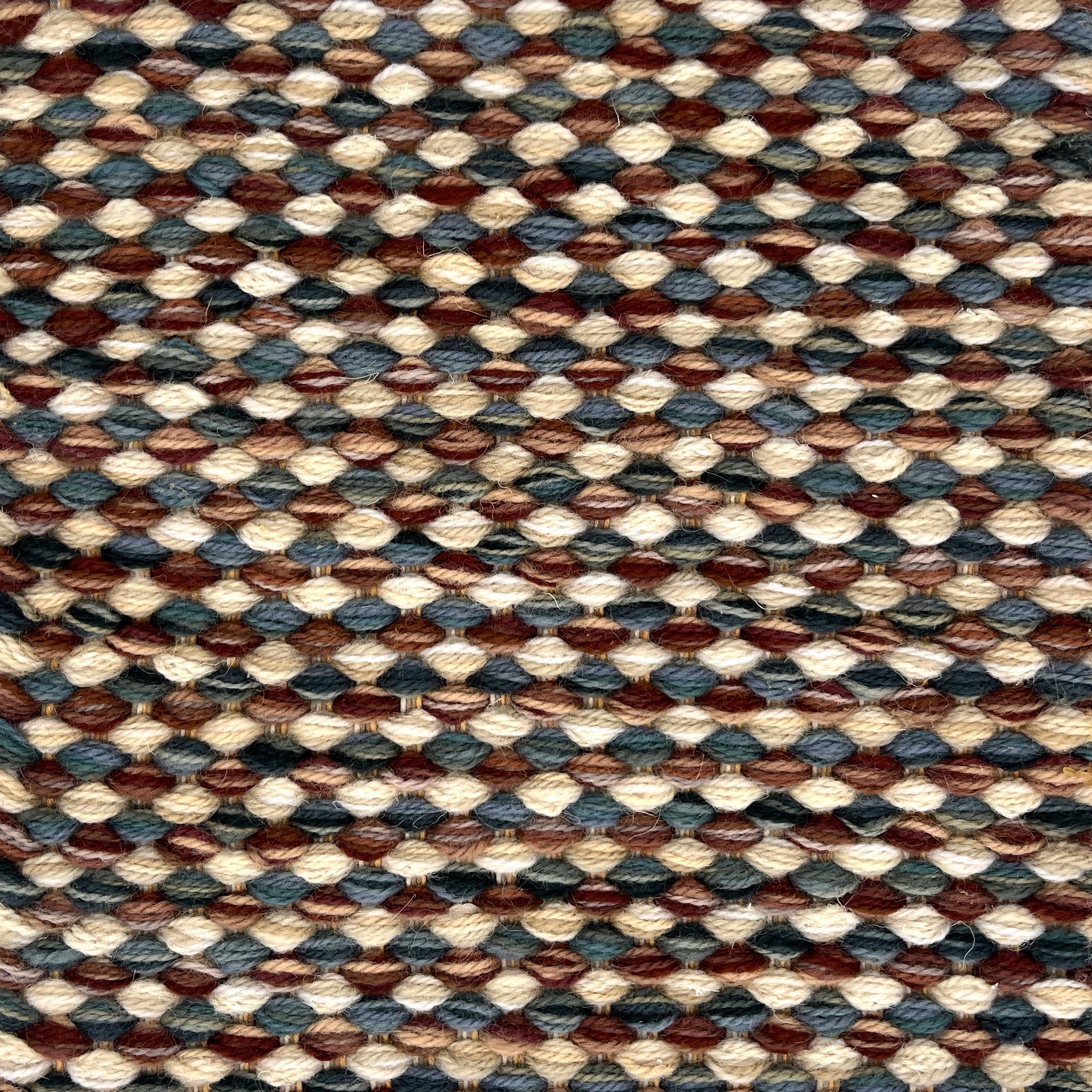 Textured handwoven rug with a strié pattern in brown, beige, and blue colors.