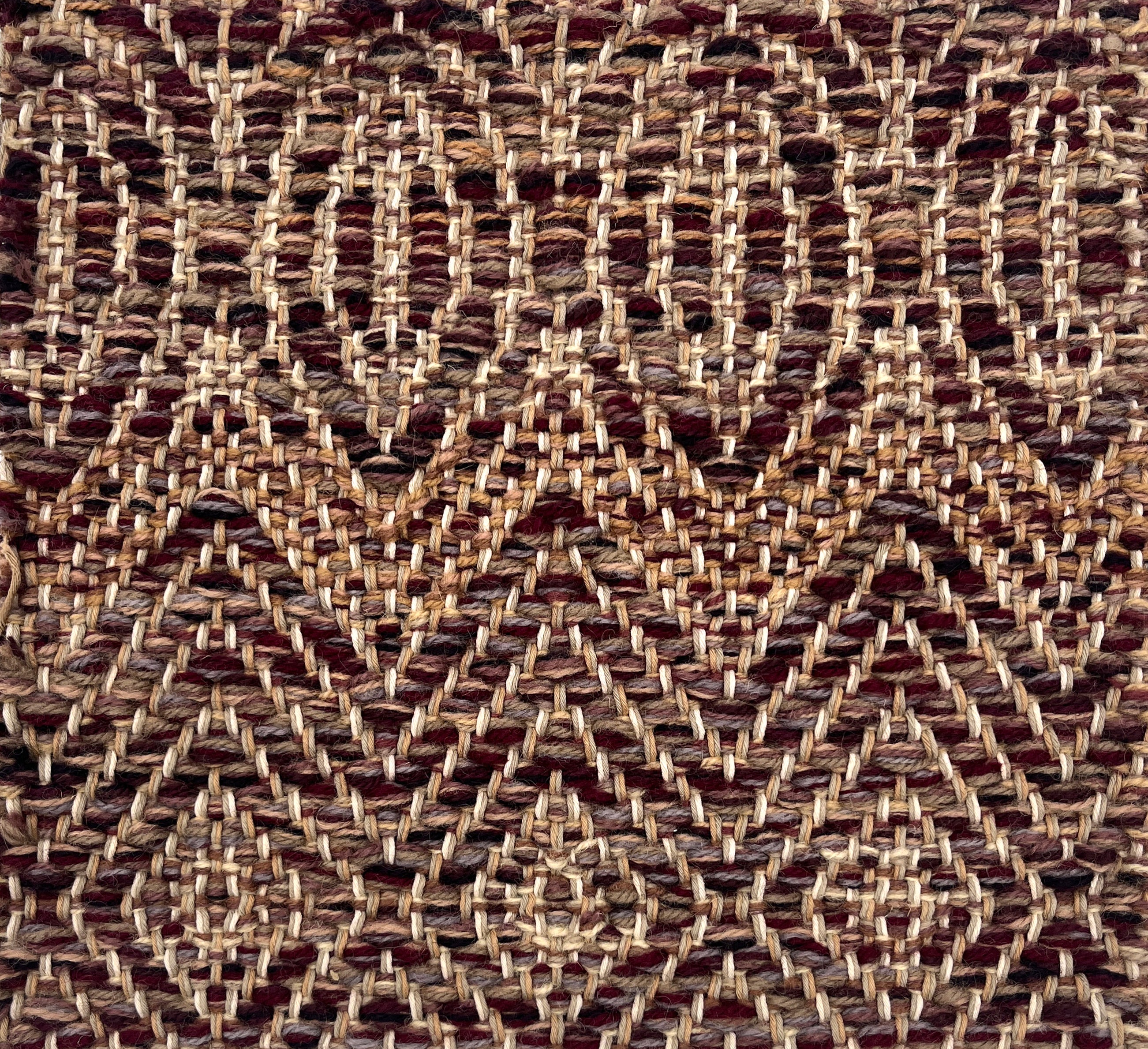 Close-up of a woven rug with subtle geometric design in brown and purple.