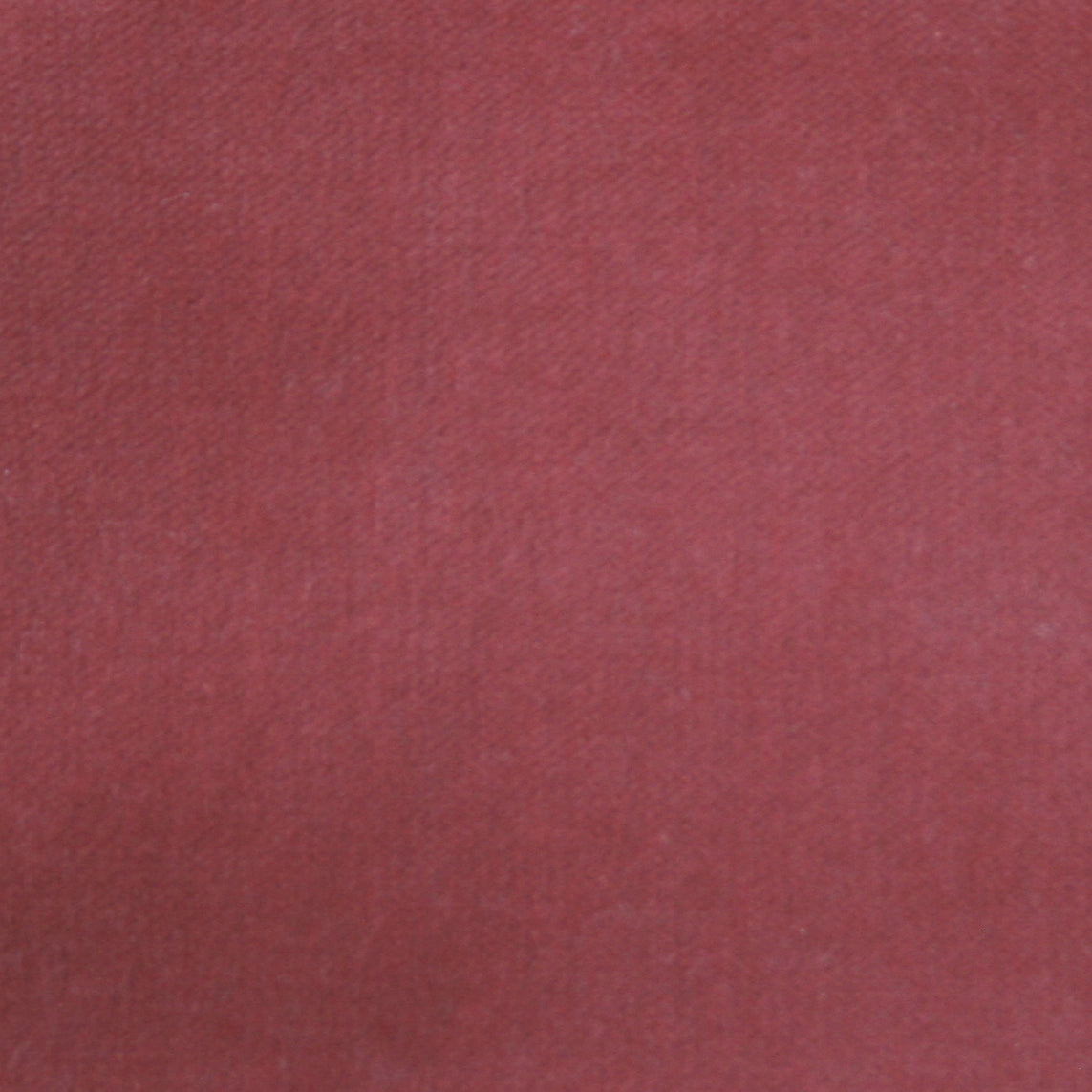 Detail of velvet fabric yardage in dusty red.