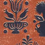 Close-up of fabric in a repeating vase and plant print in navy on a mottled rust field.