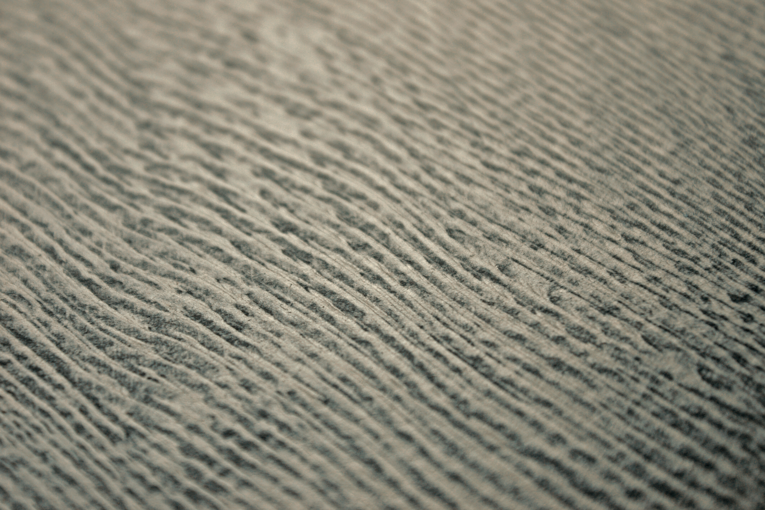Detail of a wallpaper in an abstract ridged texture in mottled gray and black.