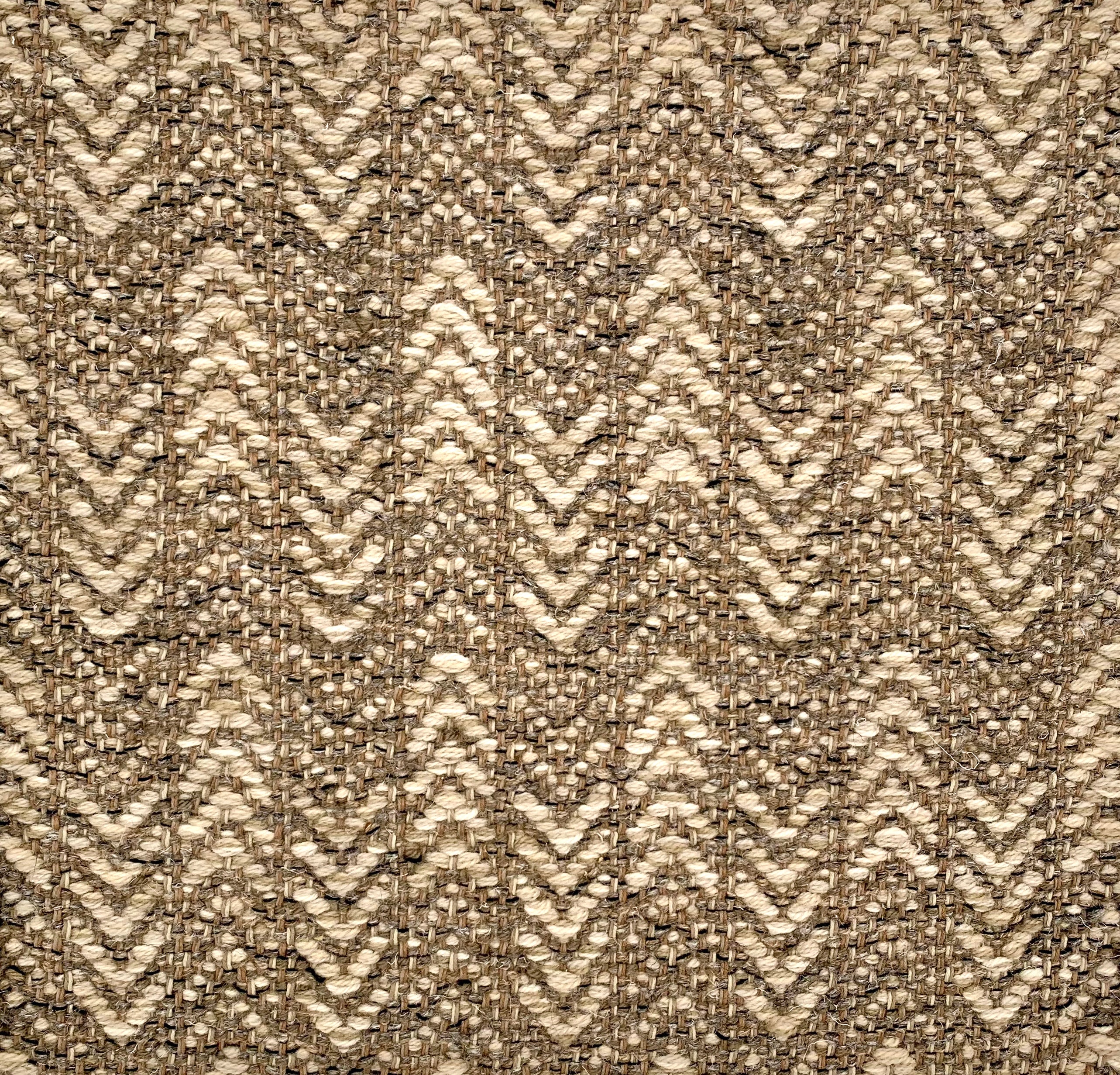 Handwoven rug detail in a herringbone design in tan and beige