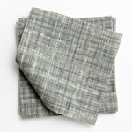 A stack of fabric swatches in a textured tweed pattern in shades of blue-gray.