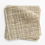 A stack of fabric swatches in a textured tweed pattern in shades of olive.