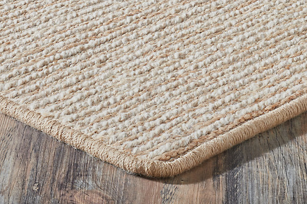 Beige woven rug on a wooden floor