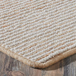 Close-up of a textured beige rug on a wooden floor