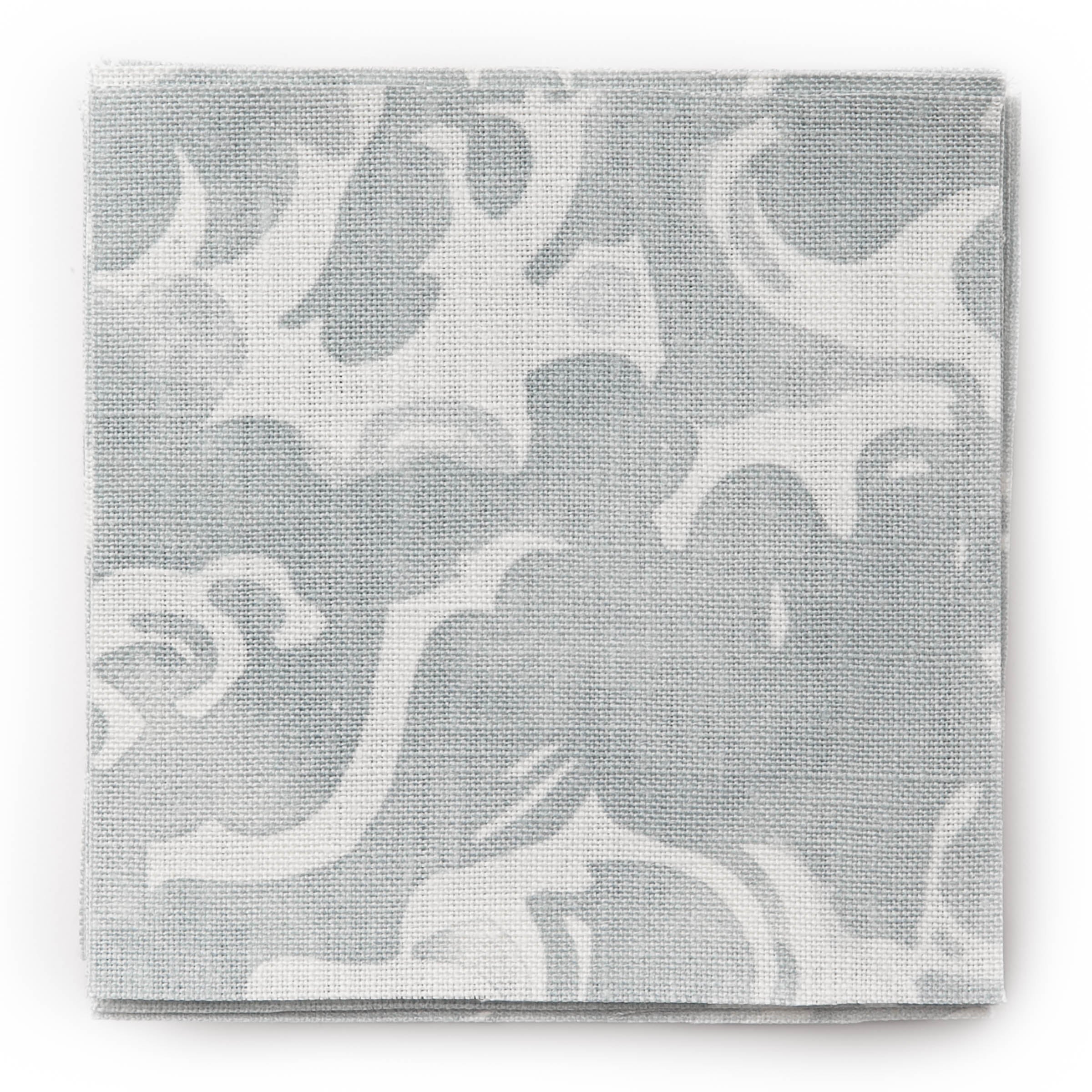 A stack of fabric swatches in a playful wave print in white on a light blue watercolor field.