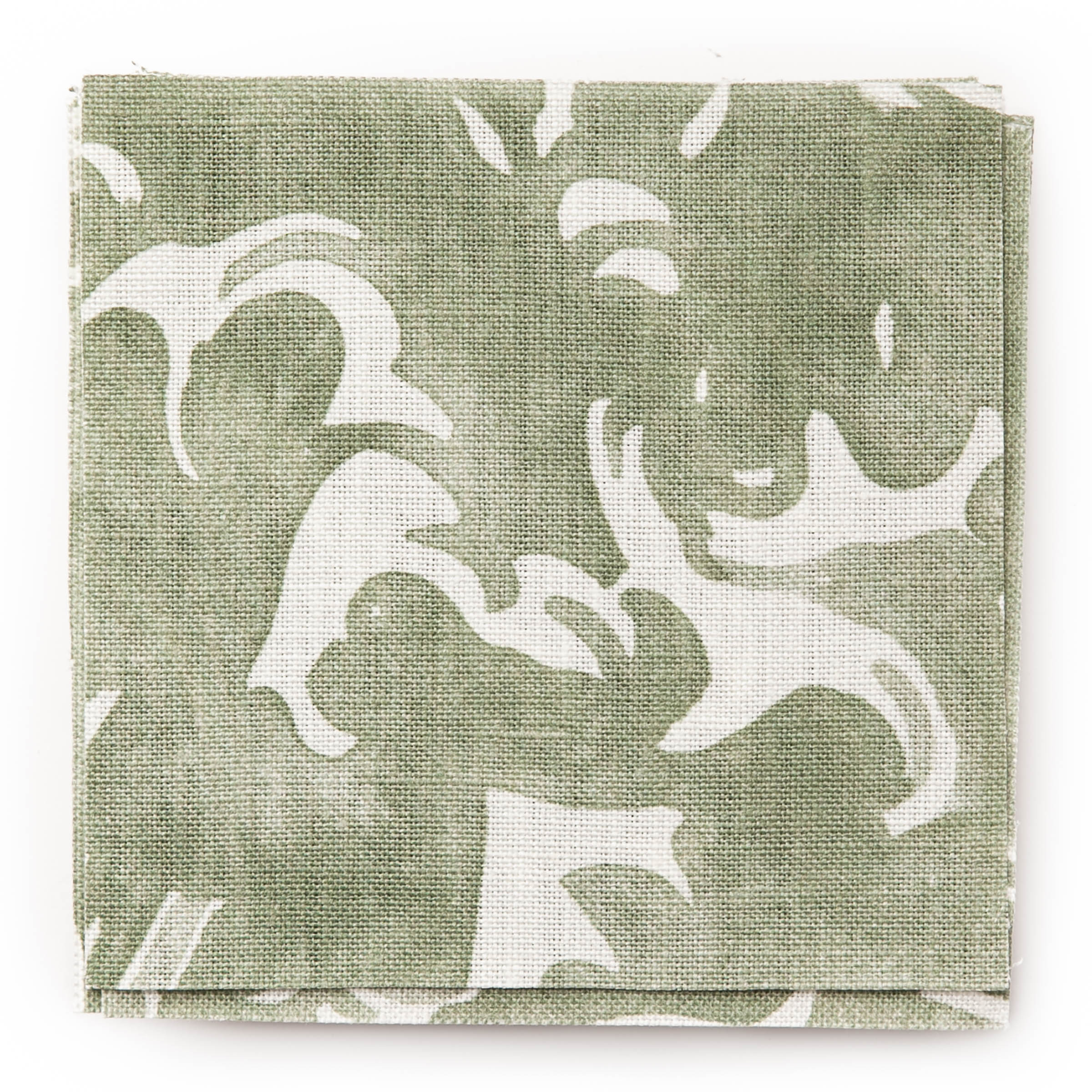 A stack of fabric swatches in a playful wave print in white on a light green watercolor field.