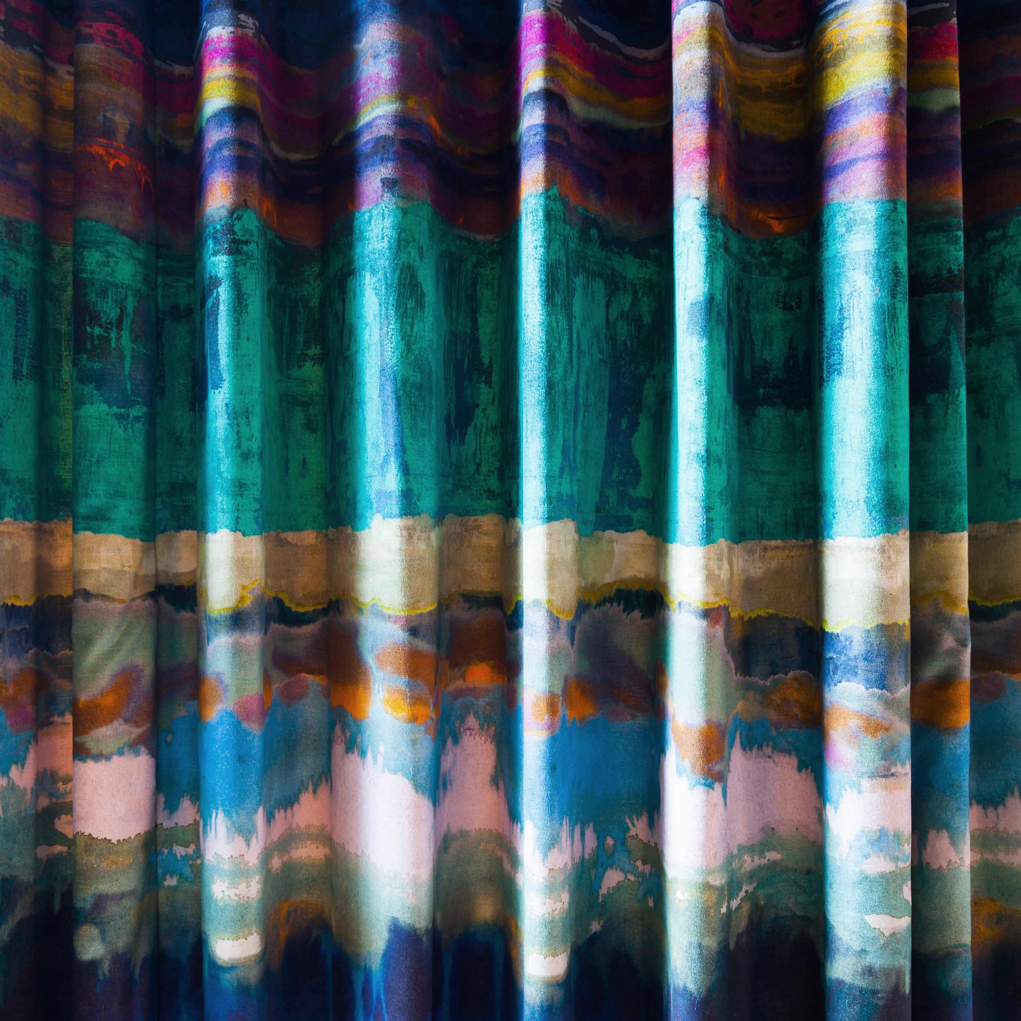 Draped fabric yardage in an abstract paint swatch print in shades of blue, turquoise and pink.