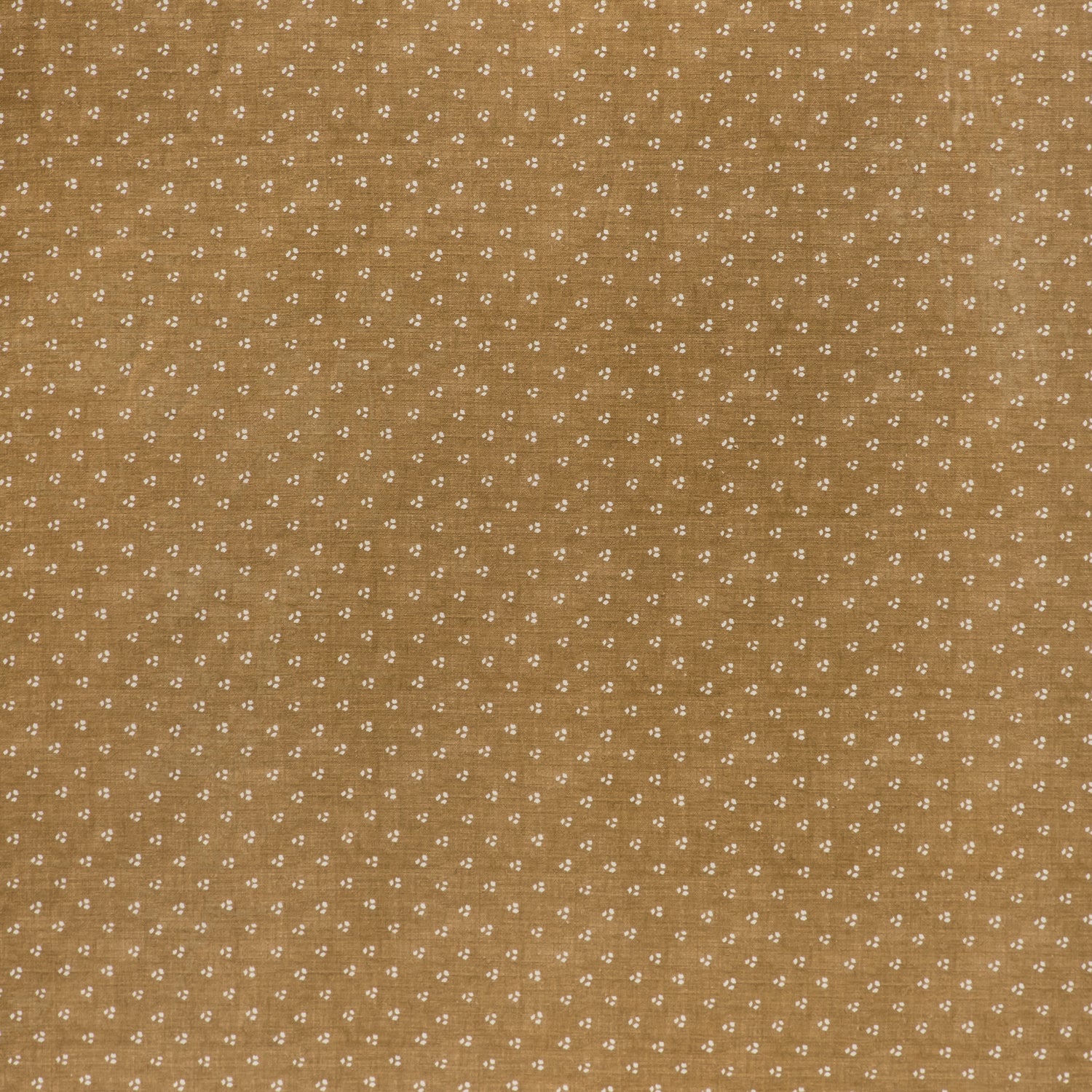 printed linen fabric in a clustered dot pattern in cream on a camel field.