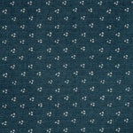 Detail of a linen fabric in a clustered dot pattern in cream on an indigo field.