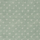 Detail of a linen fabric in a clustered dot pattern in cream on a sage field.