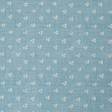 Detail of a linen fabric in a clustered dot pattern in cream on a sky blue field.