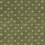 Detail of a linen fabric in a clustered dot pattern in cream on a moss field.