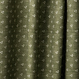 Draped printed fabric in a clustered dot pattern in cream on a moss field.