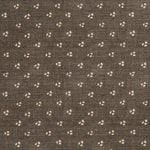 Detail of a linen fabric in a clustered dot pattern in beige on a dark gray field.