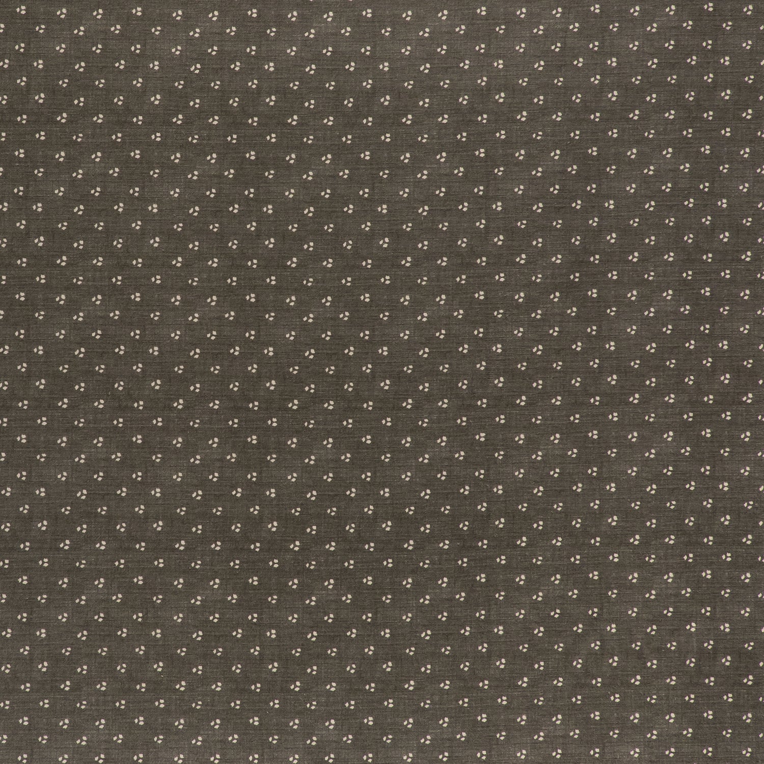 printed linen fabric in a clustered dot pattern in beige on a dark gray field.