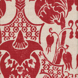 Detail of fabric in a damask vase print in red on a cream field.