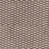 Fabric in a repeating abstract print in maroon on a tan field.