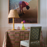 A cluttered desk and chair stand in front of a wall with a large framed print of a woman at the beach.