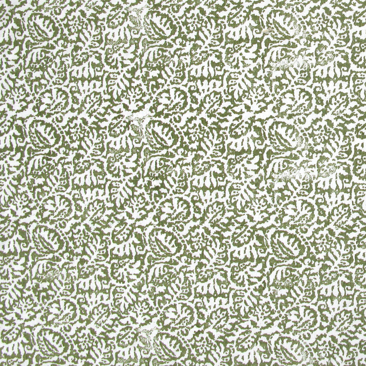 Detail of fabric in a dense paisley print in white on a mottled green field.