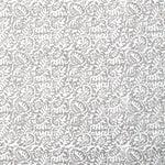 Detail of fabric in a dense paisley print in white on a mottled gray field.