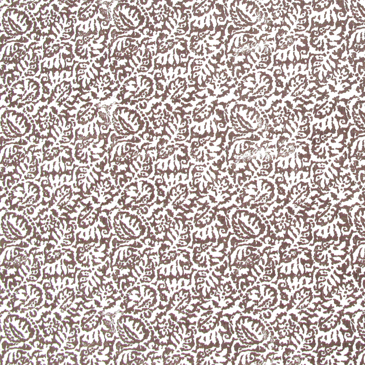 Detail of fabric in a dense paisley print in white on a mottled brown field.