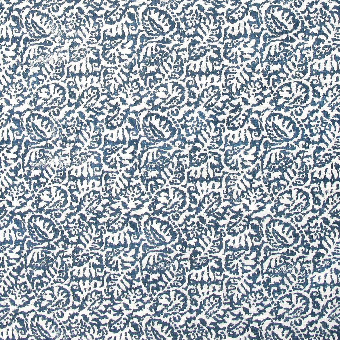 Detail of fabric in a dense paisley print in white on a mottled navy field.