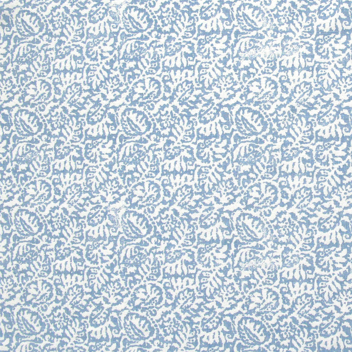 Detail of fabric in a dense paisley print in white on a light blue field.