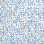 Detail of fabric in a dense paisley print in white on a light blue field.