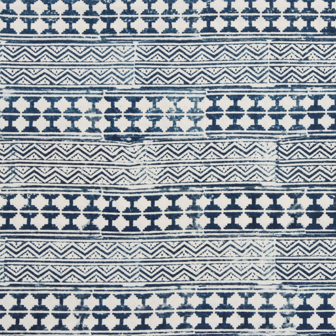 Detail of fabric in a dense geometric stripe in indigo on a white field.