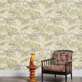 Armchair and end table in front of a wall papered in a painterly tree print in gray, yellow and cream.