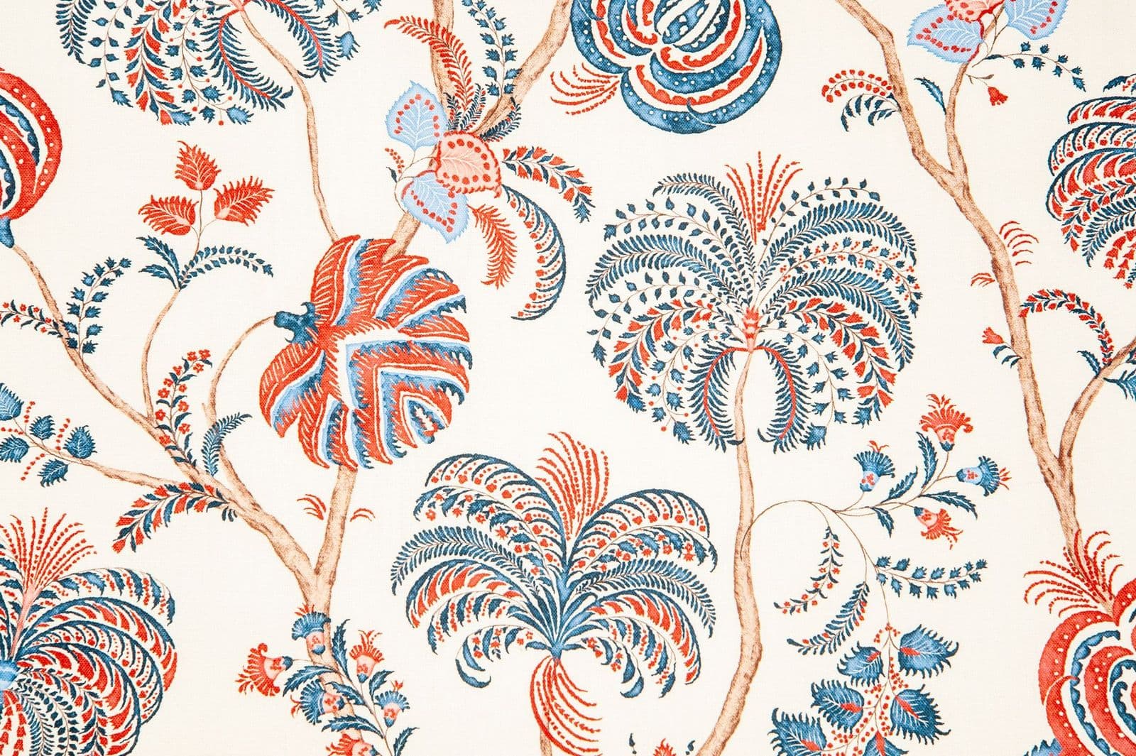 Detail of fabric in a floral paisley in shades of red, blue and brown on a white field.