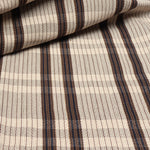 Detail of a draped hand-woven cotton fabric in soft cream in a plaid windowpane patter in cream, brown, navy and tan. 