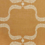 Detail of fabric in a leafy lattice print in cream on a burnt orange field.