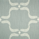 Detail of fabric in a leafy lattice print in cream on a blue-gray field.